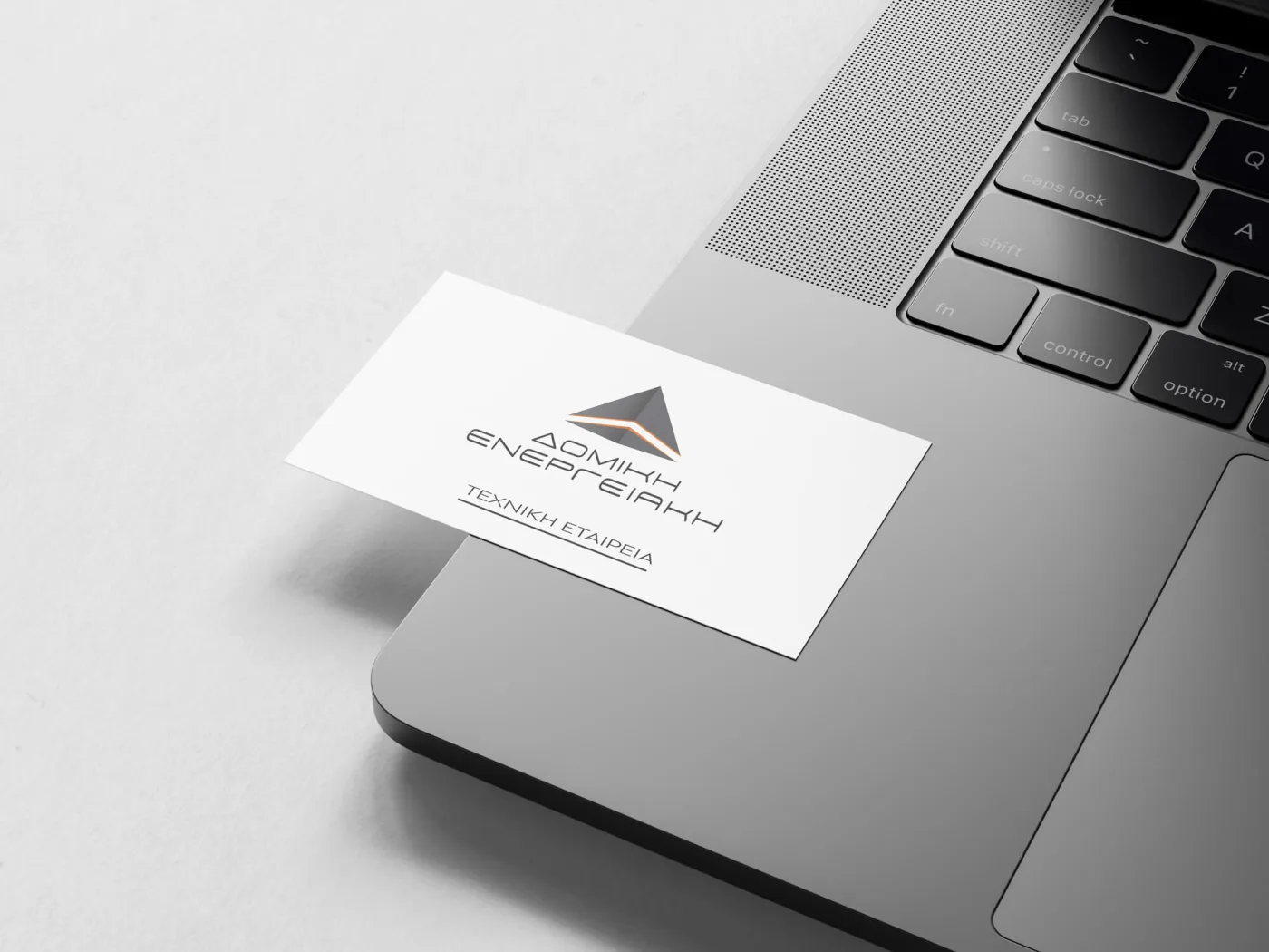 The light version of the Domiki Energeiaki business card resting on a laptop